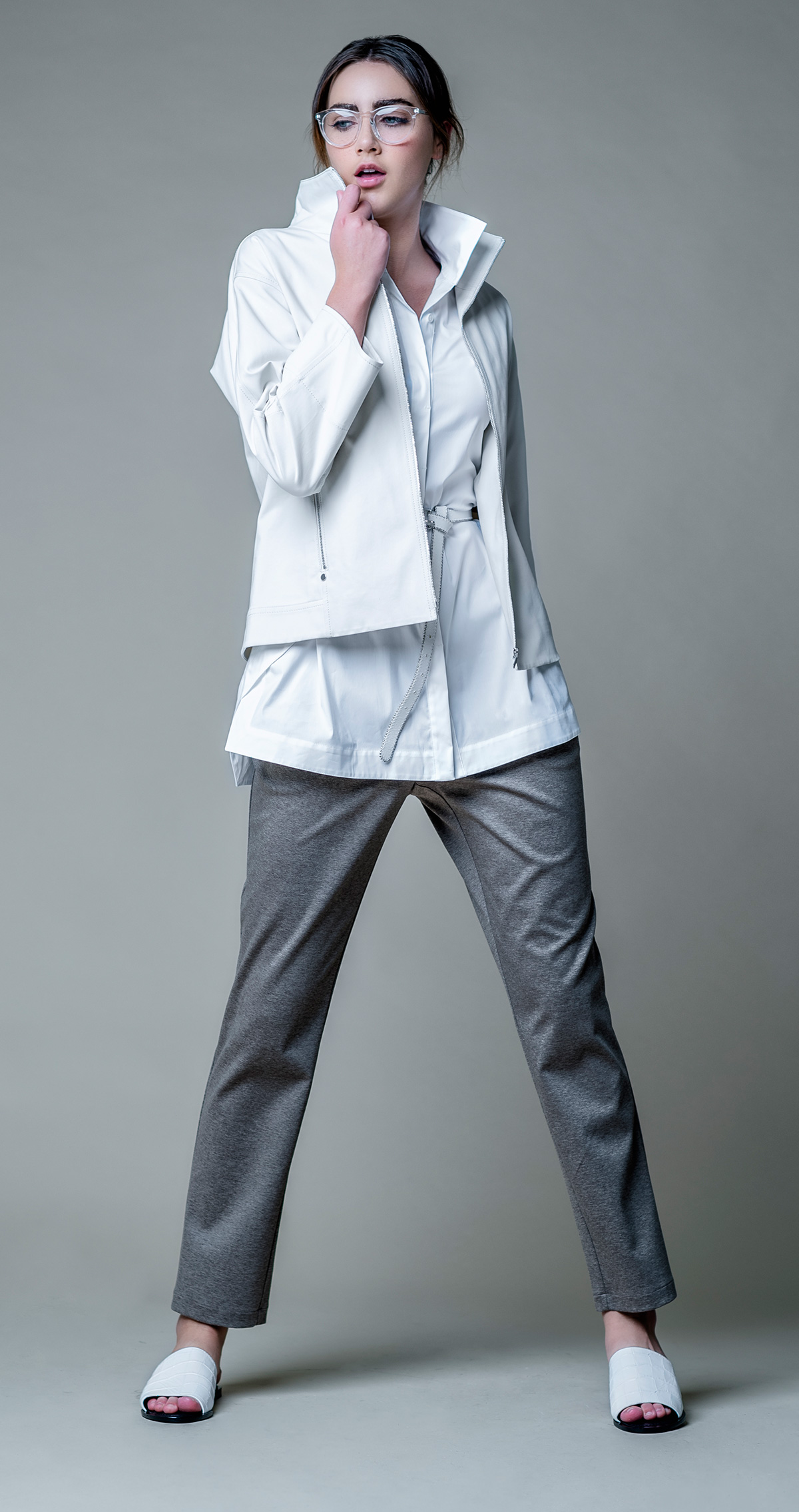 White shirt, white rain jacket, white leather belt, brown wool trousers and leather white sandals all by Lafayette 148 New York @ Brickell City Centre.