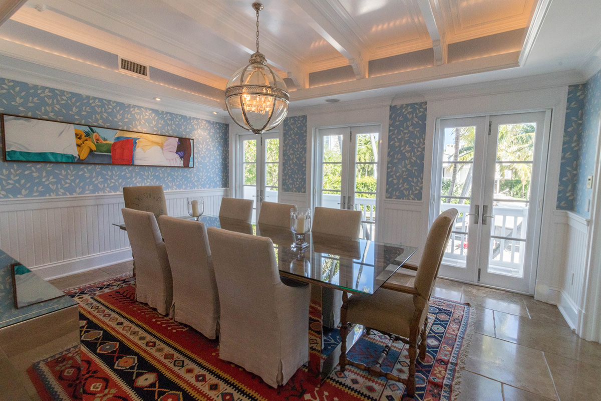 The formal dining room features walls of windows for natural illumination throughout. Entertain your guests in style and luxury as custom woodwork in the ceilings add to the luxury.