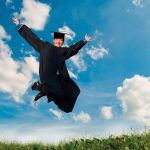 MAIN-PHOTO_7399883-young-smiley-graduate-student-in-gown-jumping-over-blue-sky