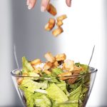 Smart-Food_5943362-preparation-of-a-caesar-salad-in-a-glass-bowl-movement-blur-of-crouton-falling-in-the-salad-selectiv