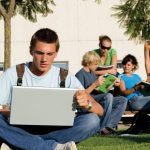 Elite-Learning_3490763-student-with-laptop-with-group-behind