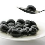 Super-Berry_6793345-black-olive-in-spoon-over-plate-with-heap-of-black-olives-in-oil