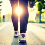 Close-up of woman athlete feet and shoes while running in park.