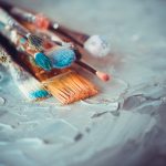 Paintbrushes on artist canvas covered  with oil paints