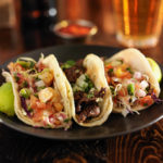 three different mexican street tacos with shrimp, steak, and fis