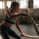 Female exercising with battle ropes