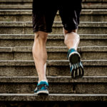 legs of young sport man with sharp scarf muscles running on stai