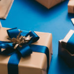 Gold boxed with blue ribbon on blue background. Xmas concept