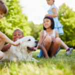 Children petting golden retriever dog