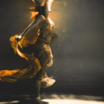 young woman swimming alone with fashion fabric underwater incognito