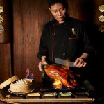 Hutong’s Chef carves into the  Flaming Peking duck
