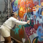 A Girls Night Out guest unleashes her creativity during an exciting graffiti spray-painting experience at Wynwood Walls